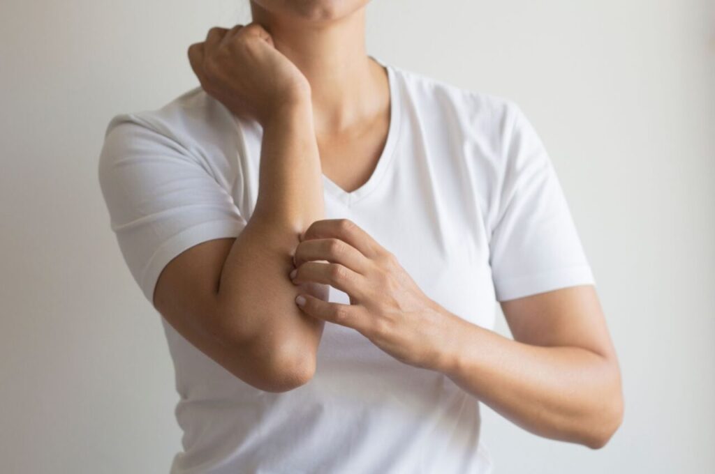 肝硬変によるかゆみで腕を書いている人