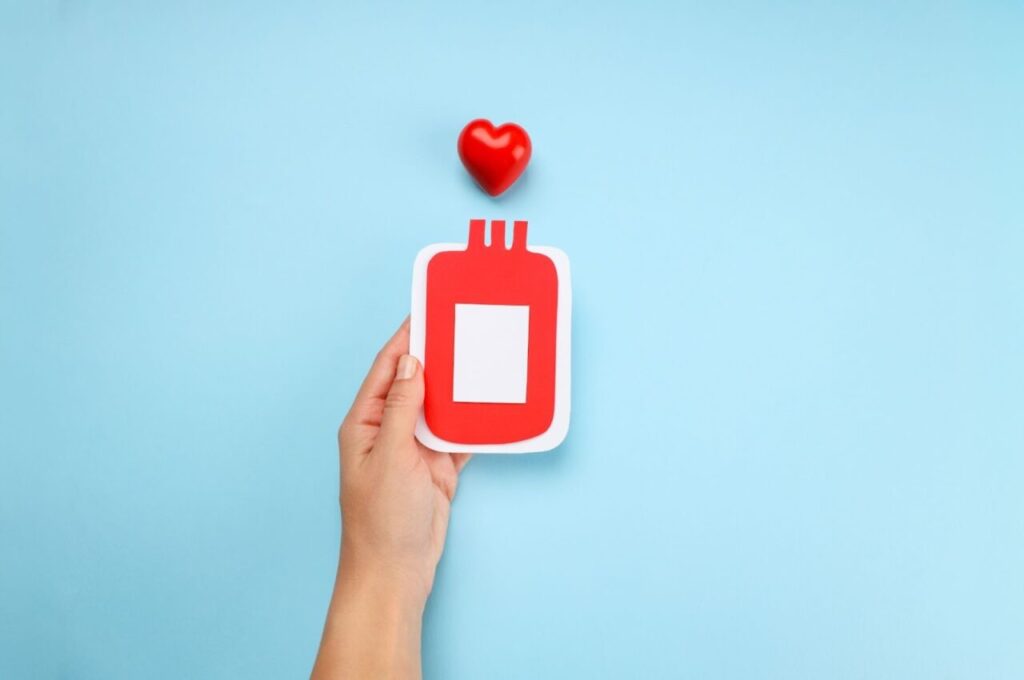 血液バッグのイラストを持っている手