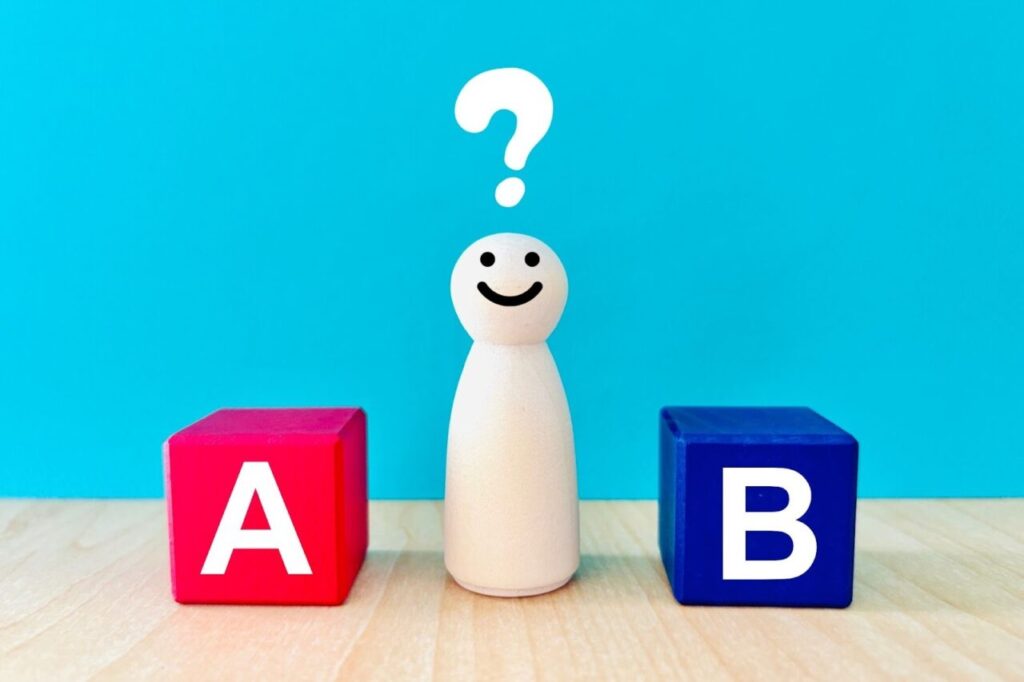 AとBが書かれた木製ブロックと中央に人形とはてなマーク