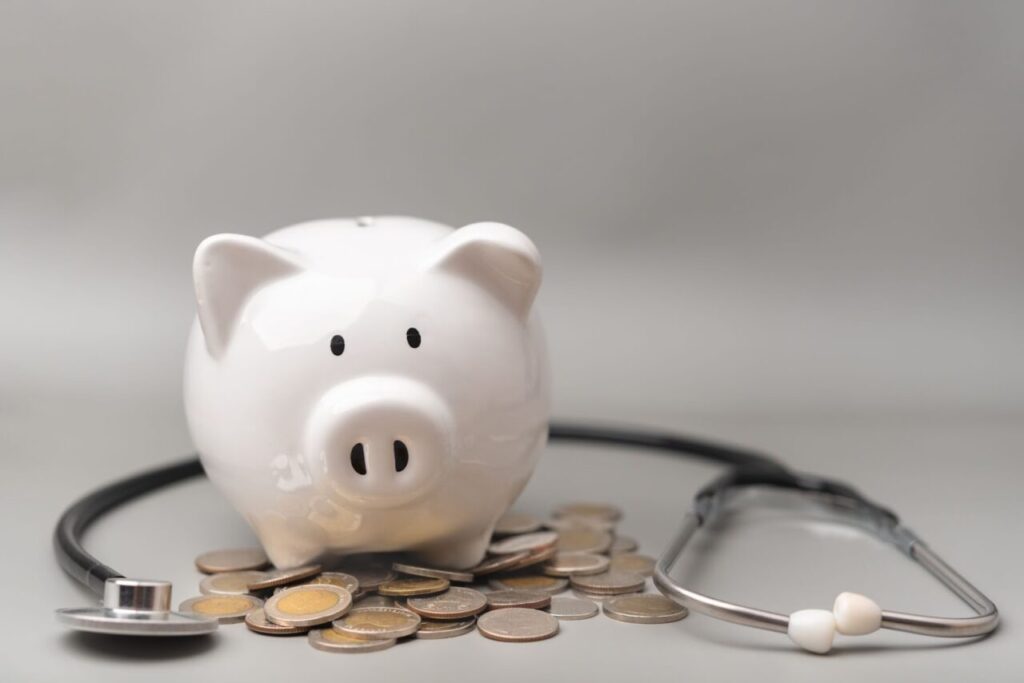 ブタの貯金箱と聴診器、コイン