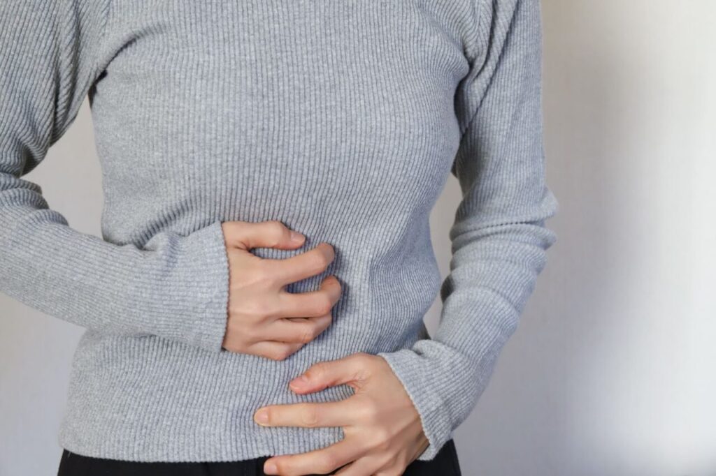 お腹を押さえている女性