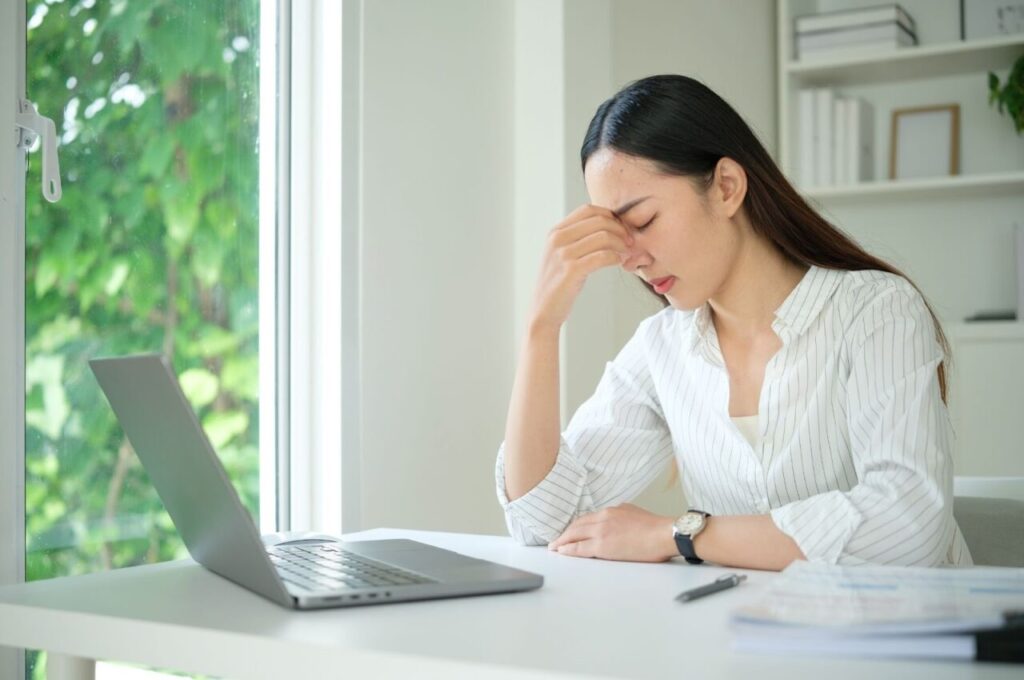 パソコンの前で疲れた様子の女性