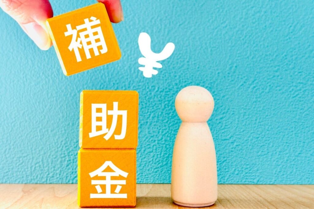 補助金と書かれたブロックと人の模型