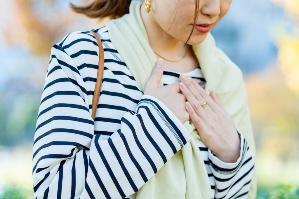 胸を押さえる女性
