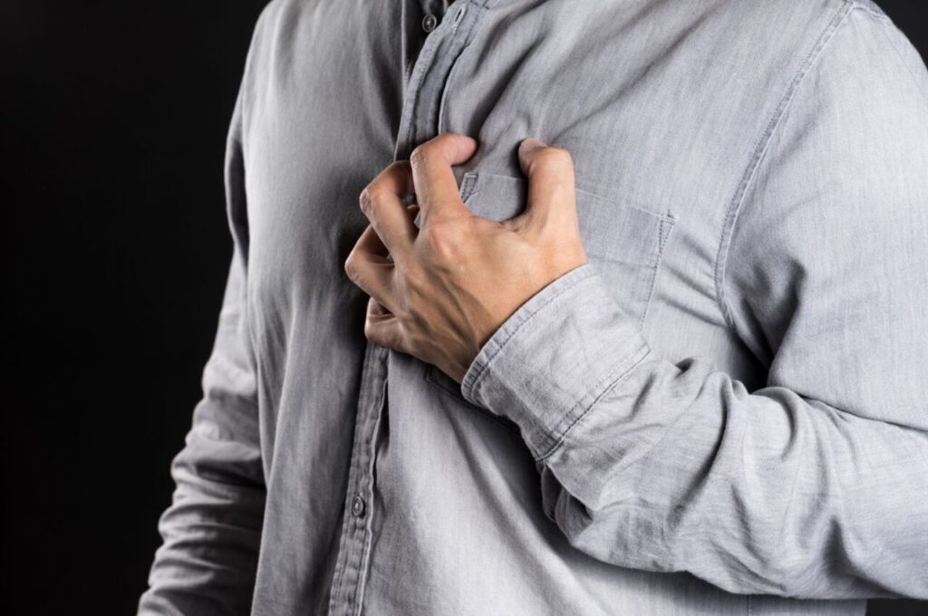 苦しそうに胸を押さえている人