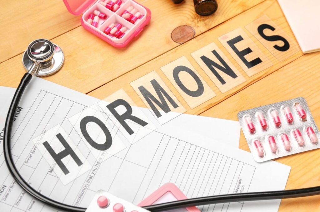 HORMONESと書かれた紙と薬、聴診器